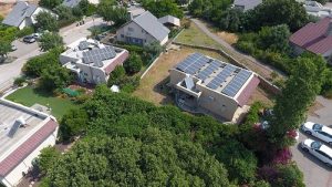 An aerial view of a climate-smart community with a solar farm shared by multiple users as members